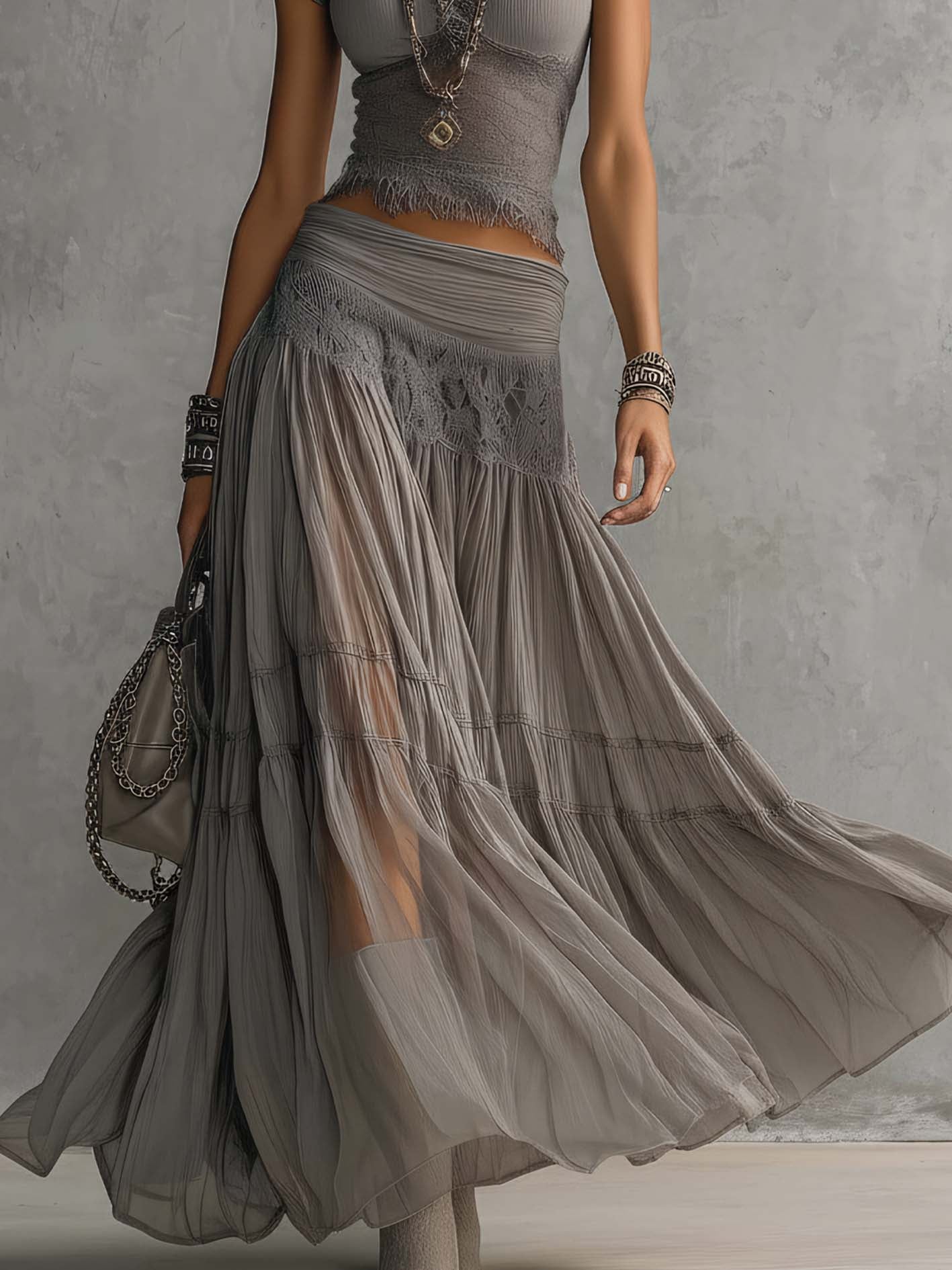 Set composto da top grigio trasparente con pannelli in pizzo e gonna maxi plissettata