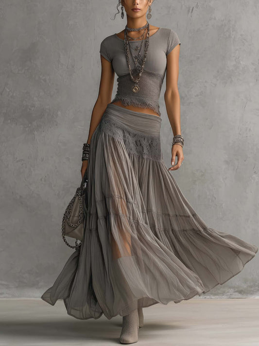 Set composto da top grigio trasparente con pannelli in pizzo e gonna maxi plissettata