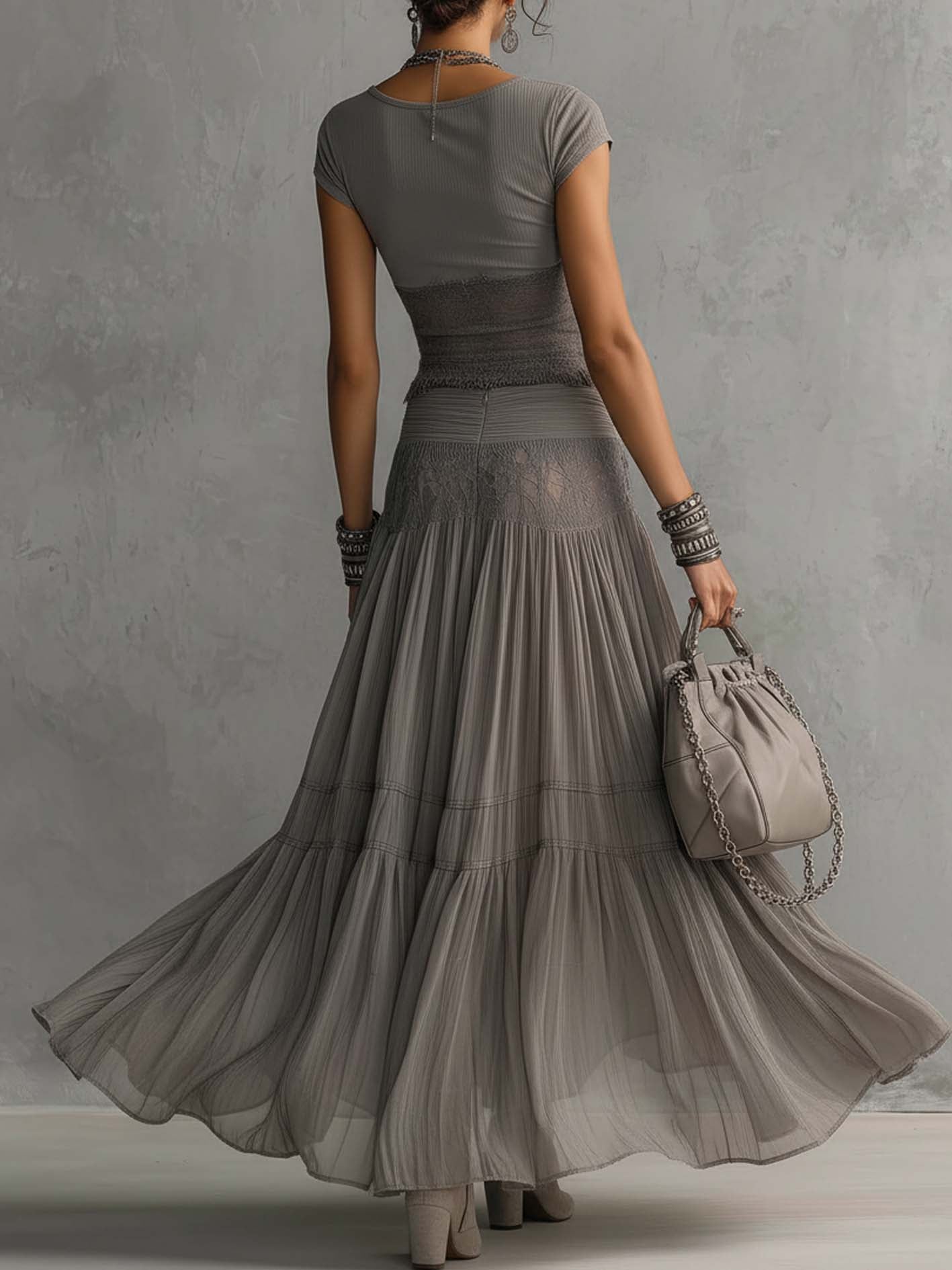 Set composto da top grigio trasparente con pannelli in pizzo e gonna maxi plissettata