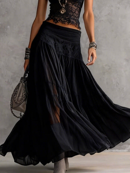 Set composto da top nero trasparente con pannelli in pizzo e gonna maxi plissettata